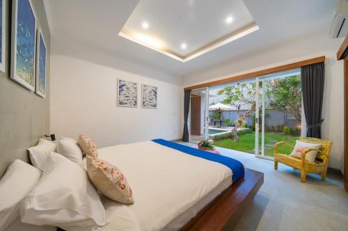 a bedroom with a bed and a large window at Villa Gemuk in Seminyak