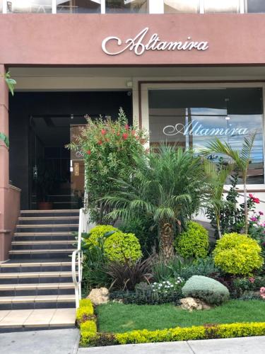Elite Apartment في كوتشابامبا: مدخل الى عمارة سكنية يوجد بها الزهور والنباتات