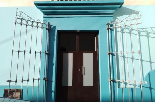 a blue building with a door and fence at Lulu'u Índigo (pequeño Índigo) in Oaxaca City