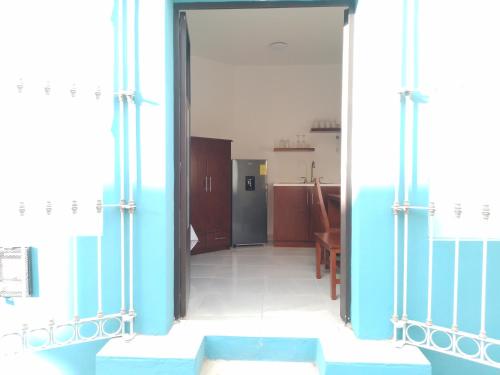 an open door to a kitchen with a refrigerator at Lulu'u Índigo (pequeño Índigo) in Oaxaca City