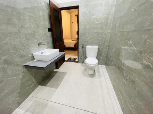 a bathroom with a toilet and a sink at New View Hikkaduwa in Hikkaduwa