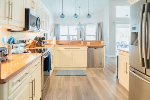 una cucina con armadietti bianchi ed elettrodomestici in acciaio inossidabile di Sovanita House Naples, FL a Naples