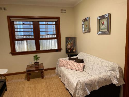 ein Wohnzimmer mit einem Sofa und einem Fenster in der Unterkunft Study/Sun room attached MQ Park/Uni/Eastwood/Ryde Spacious room in Sydney