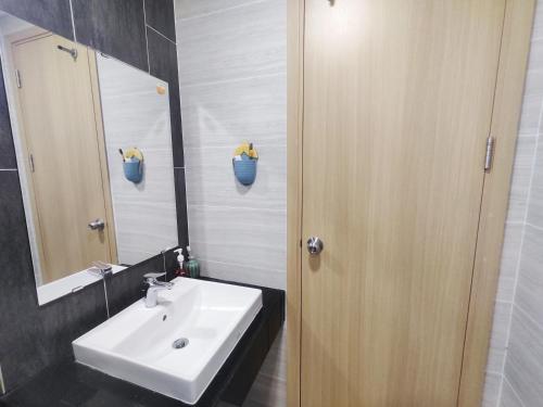 een badkamer met een witte wastafel en een spiegel bij Chung cư cao cấp Asiana Capella quận 6 in Ho Chi Minh-stad