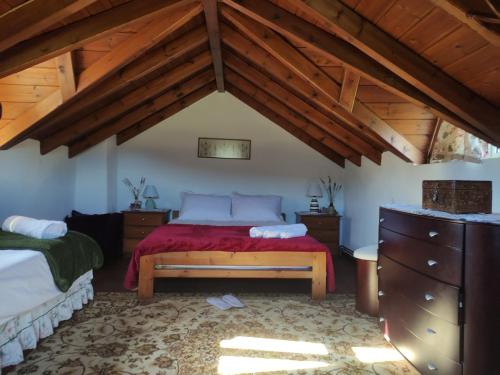 una camera con letto in una stanza con soffitti in legno di VILLA DOROTHY STUDIO a Delfi