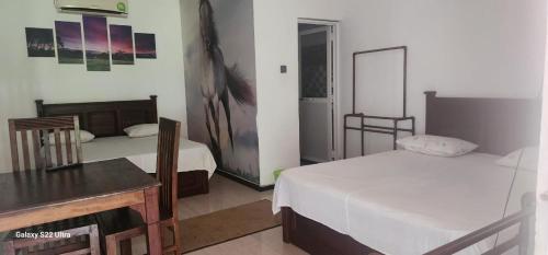 um quarto de hotel com duas camas e uma mesa em Hotel Amendra- A Coastal Escape to Embrace Sea Winds em Matara