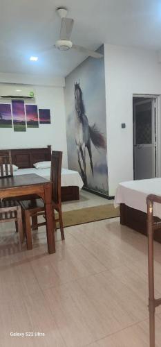 um quarto com duas camas e uma pintura de um cavalo em Hotel Amendra- A Coastal Escape to Embrace Sea Winds em Matara