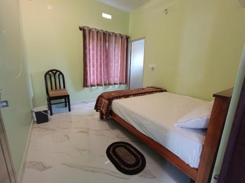 um quarto com uma cama, uma cadeira e uma janela em Sili Homestay em Madikeri