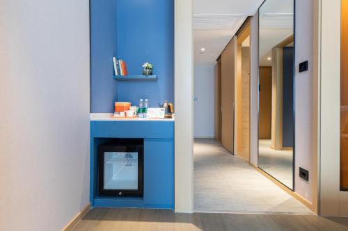 a hallway with a blue wall and a fireplace at Atour Hotel Nanjing Drum Town Qingliang Gate in Nanjing