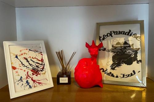 a red chicken statue sitting on a table next to a picture at Geoparadise Nishiizu in Shizuoka