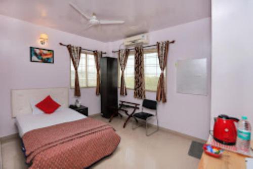 ASIAN INTERNATIONAL HOTEL, SANGLI في Sāngli: غرفة نوم بسرير ومخدة حمراء