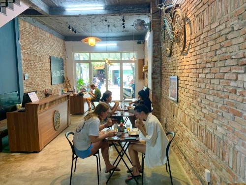 um grupo de pessoas sentadas numa mesa num restaurante em Lynk Stay Hoian em Hoi An