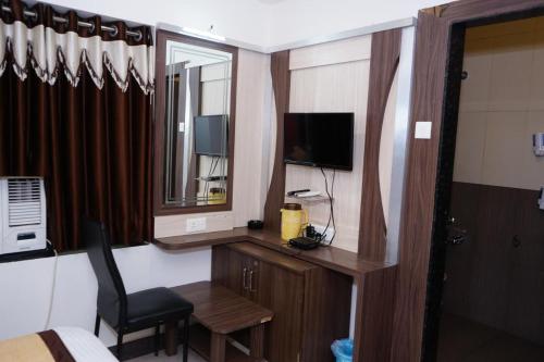 a hotel room with a desk with a chair and a television at Hotel Gopal in Dwarka