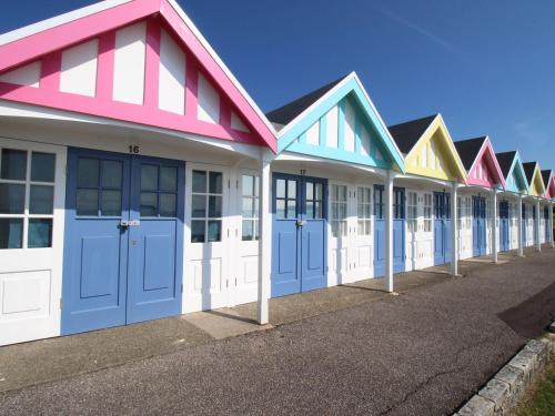 a row of colourful beach houses on a street at Fenders in Weymouth
