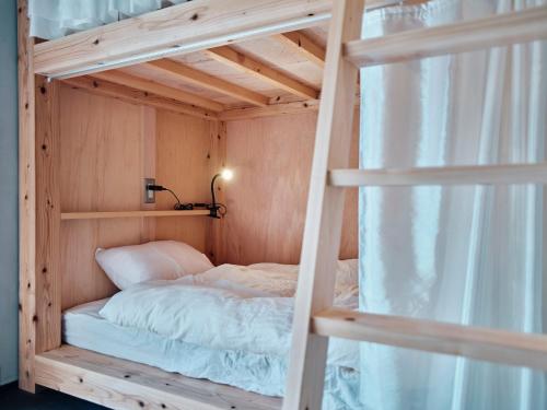 Łóżko piętrowe w drewnianym pokoju z oknem w obiekcie 小鳩屋 w mieście Asuke-chō