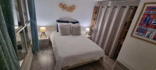 - un petit lit dans une petite chambre avec deux lampes dans l'établissement Le Tassigny, Duplex Superbe Vue sur les Quai, Centre Historique, à Sète