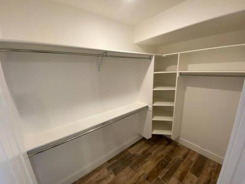 a walk in closet with white walls and wooden floors at Luxury 2 Bdrm 2 bath in heart of Salt Lake Valley in Murray