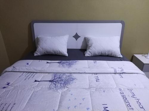 a bed with writing on the sheets and pillows at Milestone City - Appartements à louer in Antananarivo