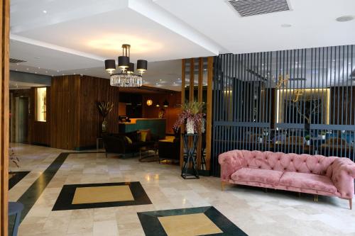 a lobby with a pink couch in a room at Turk Inn Ferro Hotel in Çekirge