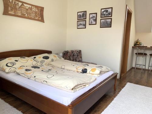 a bedroom with a bed with white sheets and a chair at Penzion Olga Hajasova in Bojnice