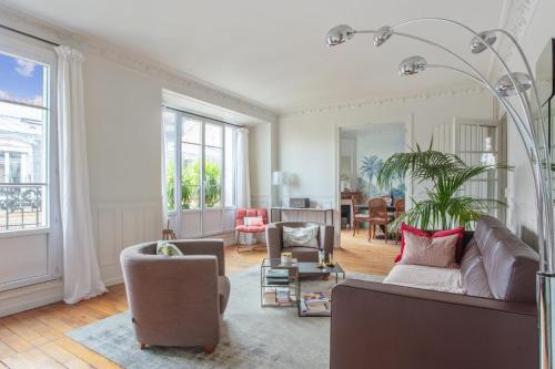 un salon avec un canapé et une chaise dans l'établissement Appartement du Fenoux - Welkeys, à Paris