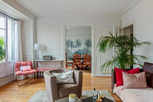 un salon avec un canapé et des chaises dans l'établissement Appartement du Fenoux - Welkeys, à Paris
