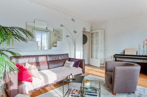 - un salon avec un canapé et un piano dans l'établissement Appartement du Fenoux - Welkeys, à Paris