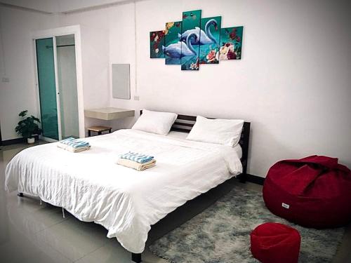 a bedroom with a white bed with a red bag on it at MY HOME Hotel - Phutthamonthon 4 Road, near Mahidol University Salaya in Ban Krathum Lom