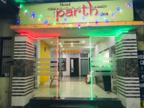Hotel Parth Inn, WARDHA في Wardha: صالة للحفلات بها لافتة نيون وأضواء