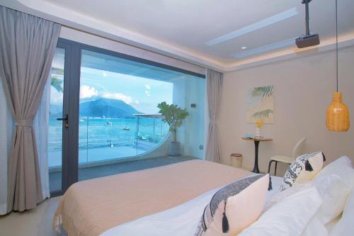 a bedroom with a bed and a view of the ocean at Shenzhen Semporna Beach Sea View B & B - 深圳较场尾仙本那沙滩海景民宿 in Shenzhen