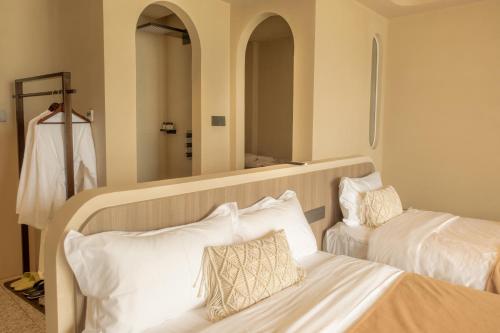 a hotel room with two beds and a mirror at Shenzhen Semporna Beach Sea View B & B - 深圳较场尾仙本那沙滩海景民宿 in Shenzhen