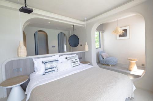 a white bedroom with a large bed and a chair at Shenzhen Semporna Beach Sea View B & B - 深圳较场尾仙本那沙滩海景民宿 in Shenzhen