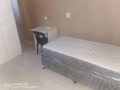 a bed in a room with a desk next to it at Kpt property investment in Soweto