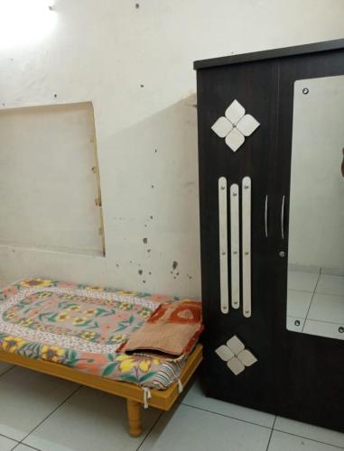 a wooden cabinet with a bed in a room at Oonesty Home Stay in Ahmedabad