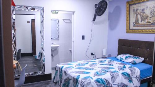 a bedroom with a bed and a bathroom with a mirror at Hostal Queens Deluxe in Florencia