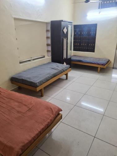 a room with two beds in a room at Oonesty Home Stay in Ahmedabad