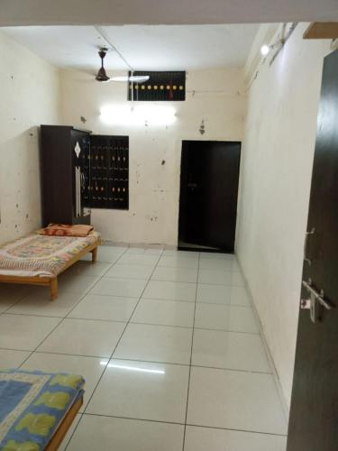 a room with a room with a bed and a door at Oonesty Home Stay in Ahmedabad