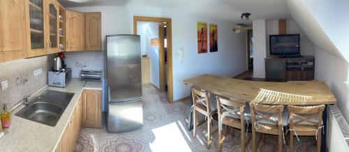 a kitchen with a sink and a table and a refrigerator at Penzion Olga Hajasova in Bojnice