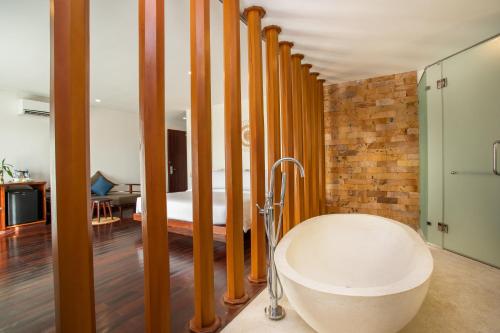 a bathroom with a bath tub and a bedroom at Mera Residence in Siem Reap