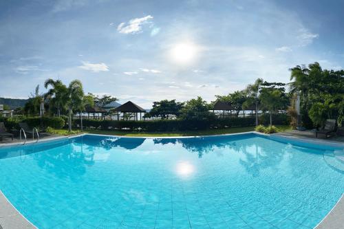 une grande piscine bleue dans un complexe dans l'établissement RSAM Beach Resort by Cocotel, à Nasugbu