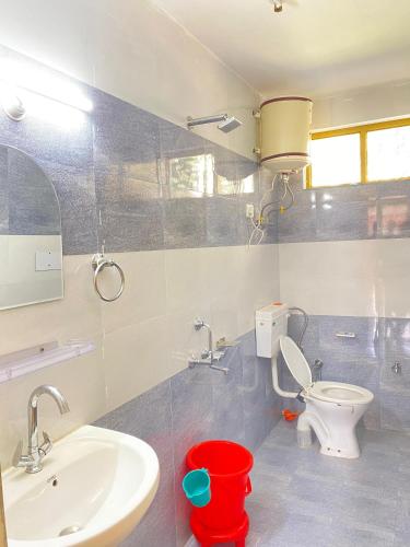 een badkamer met een wit toilet en een wastafel bij Fresco Moonlight in Manāli