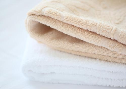 a stack of towels sitting on a pile of towels at APA Hotel Ishigakijima in Ishigaki Island