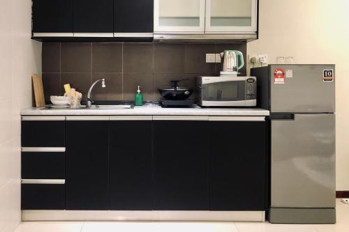 a kitchen with a microwave and a refrigerator at Comfy-Concept Apartment @ B.Bintang (3min walk LRT, Lalaport, TimeSquare) in Kuala Lumpur