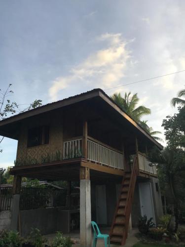Batuan的住宿－Chloe’s Paradise Hostel，一座带甲板和蓝色椅子的房子