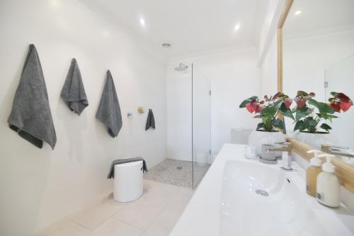 a white bathroom with a toilet and a sink at Oceans Guest House & Luxurious Apartments in Struisbaai