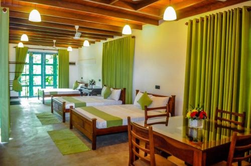 Habitación de hotel con 2 camas y mesa en Uma Garden Kandegedara, en Matugama