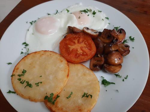 a white plate of food with eggs and mushrooms at Casa Mia in Pietermaritzburg