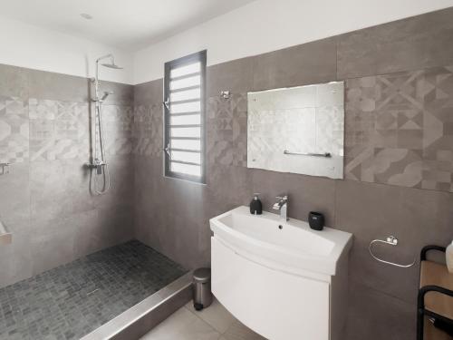 a bathroom with a white sink and a mirror at Résidence Celestial - Premium 3 bedrooms Villa with volcanic stone Pool in Grand Baie