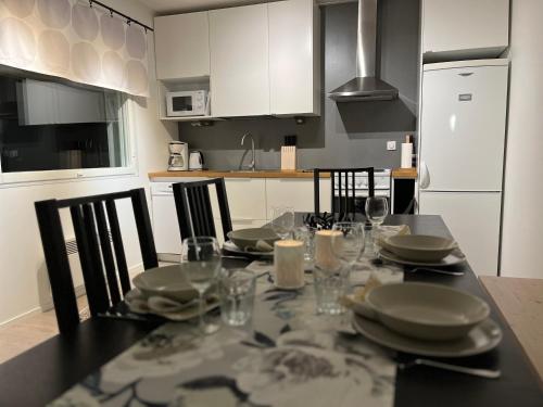 a kitchen with a table with plates and glasses on it at Kuurala apartment in Rovaniemi