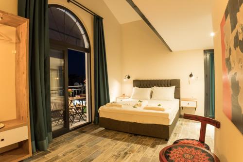 a bedroom with a bed and a balcony at JULİETOTEL in Alacati